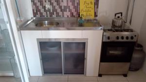 a small kitchen with a sink and a stove at Casa Residencial Duque de Caxias in Arroio do Sal
