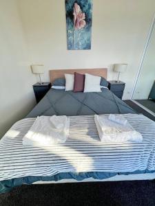 a bedroom with a bed with two towels on it at Spacious & High in the Skyplaza - 1bd 1bth Apt in Phillip