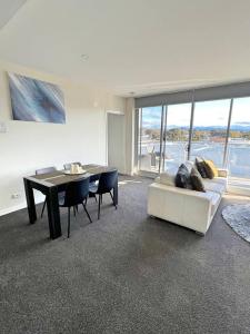 a living room with a couch and a table with chairs at Spacious & High in the Skyplaza - 1bd 1bth Apt in Phillip