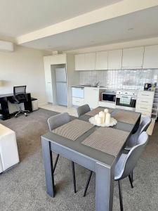 a kitchen with a table and chairs in a room at Spacious & High in the Skyplaza - 1bd 1bth Apt in Phillip
