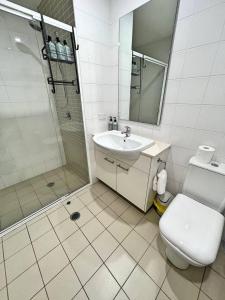 a bathroom with a toilet and a sink and a shower at Spacious & High in the Skyplaza - 1bd 1bth Apt in Phillip