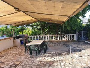 un patio avec une table et des chaises sous un toit dans l'établissement Casa rural en Padul entre Sierra Nevada y la Costa, à Grenade