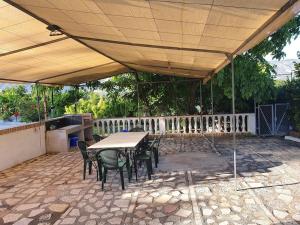 a patio with a table and chairs under a roof at Casa rural en Padul entre Sierra Nevada y la Costa in Granada