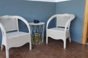 2 sillas de mimbre y una mesa en una habitación en Casa rural en Padul entre Sierra Nevada y la Costa, en Granada