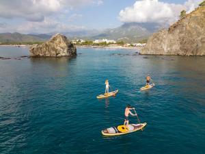 three people are on paddle boards in the water at Rixos Premium Tekirova - The Land of Legends Access in Tekirova