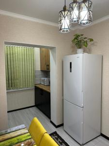 uma cozinha com um frigorífico branco num quarto em Двухкомнатная квартира em Shymkent