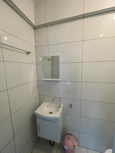 a white bathroom with a toilet and a mirror at Apartamento Onda Azul in Balneário Camboriú