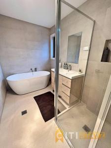 y baño con bañera, lavamanos y ducha. en Lavish in Lyons - 3bd 2bth Spacious & Modern Home en Lyons