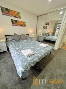 a bedroom with a large bed and a mirror at Lavish in Lyons - 3bd 2bth Spacious & Modern Home in Lyons