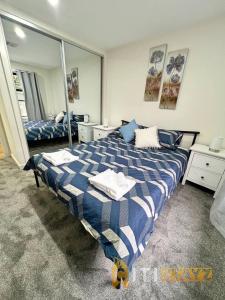 Schlafzimmer mit einem blauen und weißen Bett und einem Spiegel in der Unterkunft Lavish in Lyons - 3bd 2bth Spacious & Modern Home in Lyons