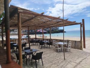 un restaurante en la playa con mesas y sillas en Maison de charme dans la capitale en Moroni