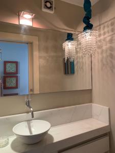 un baño con lavabo y espejo en Apartamento Ilhas do Sul, en Balneário Camboriú 5 fotos más