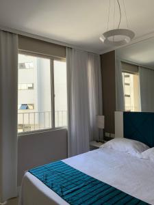 Un dormitorio con una cama y una ventana grande en Apartamento Ilhas do Sul, en Balneário Camboriú