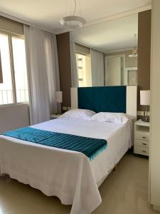 Un dormitorio con una cama grande con cabecero azul. en Apartamento Ilhas do Sul, en Balneário Camboriú
