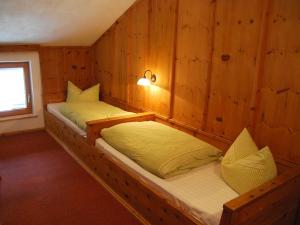 ゲルロスにあるPension Wassererhofのベッド2台 木製の壁の部屋