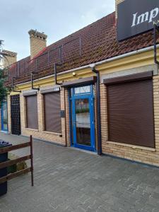 un magasin avec une porte bleue sur un bâtiment dans l'établissement Bogate Studio, à Żywiec