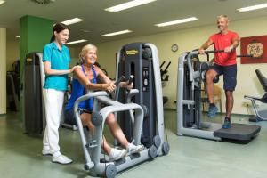 three people exercising on tread machines in a gym at Gesundheits- & Wellness Resort Oberzeiring in Oberzeiring