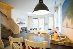 comedor y sala de estar con mesa y sillas en Amelander Kaap appartement 1, en Hollum