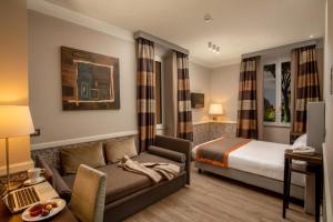 ein Hotelzimmer mit einem Bett und einem Sofa in der Unterkunft Fragrance Hotel St. Peter in Rom
