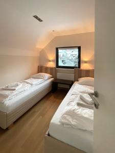 two beds in a room with a tv on the wall at Ian's Residence in Kranjska Gora