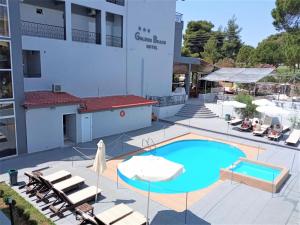 uma piscina com espreguiçadeiras e um edifício em Golden Beach Hotel em Metamorfosi