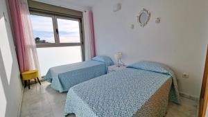 a room with two beds and a window at Large and sunny all-day balcony with stunning sea views in Benidorm