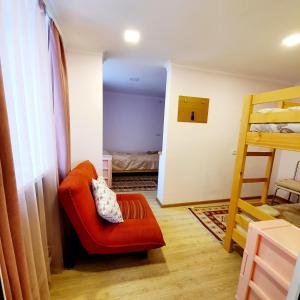 Cette chambre dispose d'une chaise rouge et de lits superposés. dans l'établissement Sunhome Stepanavan Guest House, à Stepanavan