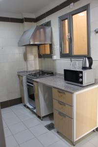 a kitchen with a stove and a sink at ماجيك سويت المهبولة 5 Magic Suite ALMahboula 5 in Kuwait