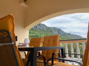 a balcony with a table and chairs and a mountain at Apartman "Anna" in Bribir