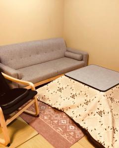 a living room with a couch and a chair at Utatei Sou in Takayama