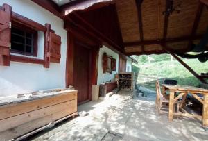 a porch of a house with a wooden table at Nature Lodge Csesztve in Csesztve