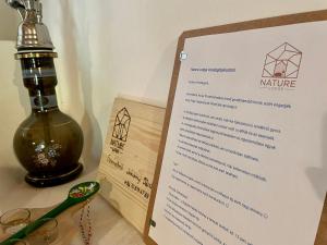 a menu with a bottle and a pair of scissors at Nature Lodge Csesztve in Csesztve