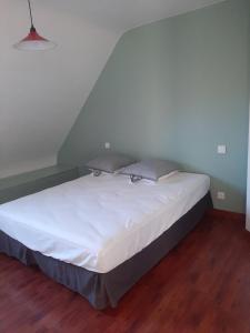 1 cama con sábanas blancas y almohadas en una habitación en ESMAEL, en Larmor-Baden