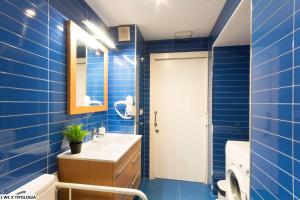 Un baño azul con lavabo y espejo. en Valentia Apartments - Mercado Central, en Valencia 23 fotos más
