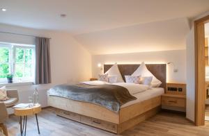 Schlafzimmer mit einem großen Bett mit einem Kopfteil aus Holz in der Unterkunft Hotel Bad Rain in Oberstaufen