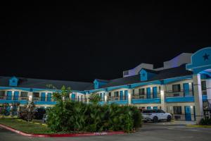 un gran edificio azul con coches estacionados en un estacionamiento en Hotel Bliss Kemah, en Kemah