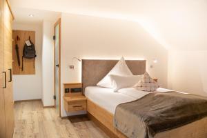 a bedroom with a bed with white sheets and pillows at Hotel Bad Rain in Oberstaufen