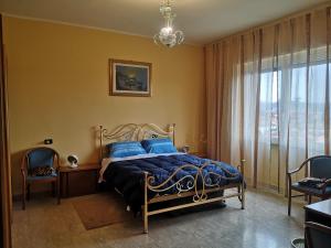 una camera da letto con un letto con cuscini blu e una finestra di Next b&b a Frosinone