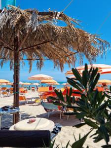 una playa con sillas y sombrillas en la arena en CASA FLAN en Porto San Giorgio