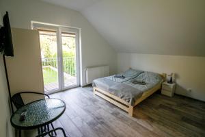 sypialnia z łóżkiem, stołem i oknem w obiekcie Leśny zakątek w mieście Rybno