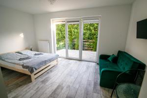 sypialnia z łóżkiem i zieloną kanapą w obiekcie Leśny zakątek w mieście Rybno