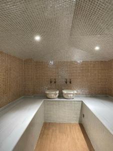 uma casa de banho com 2 lavatórios numa parede de azulejos em Seven Beauties Hotel Spa Restaurant, Old City Baku em Baku