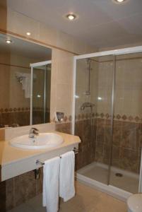 La salle de bains est pourvue d'un lavabo et d'une douche. dans l'établissement Hostal Los Valles, à Bielsa