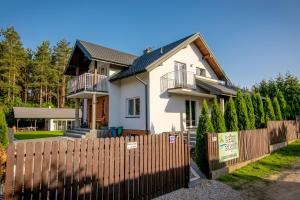 a house with a wooden fence in front of it at Leśny zakątek in Rybno