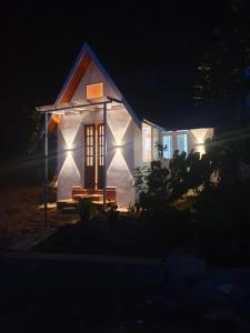 Une petite maison blanche éclairée la nuit dans l'établissement Gardenia Villa Munnar, à Munnar