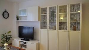 Cette chambre comprend une armoire blanche et une télévision. dans l'établissement Apartamento Estelas de Cantabria, à Los Corrales de Buelna