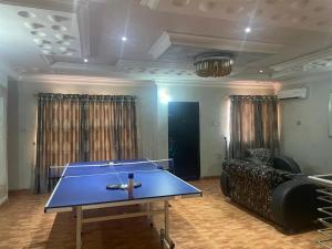 a ping pong table in a living room with a couch at Aries Apartment in Lagos