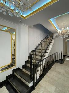 eine Treppe mit einem Spiegel und einem Kronleuchter in der Unterkunft Seven Beauties Hotel Spa Restaurant, Old City Baku in Baku