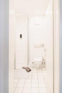 a white bathroom with a shower and a toilet at Villa Ludwigsburg in Kühlungsborn