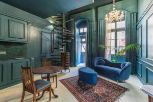 uma sala de estar com mobiliário azul e uma escada em espiral em House of W em Valletta